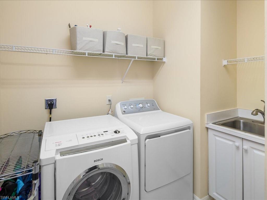 Laundry room with separate washer and dryer and cabinet space