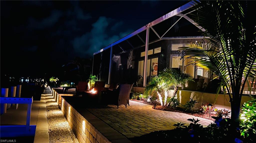 Deck at night with a patio area and a lanai