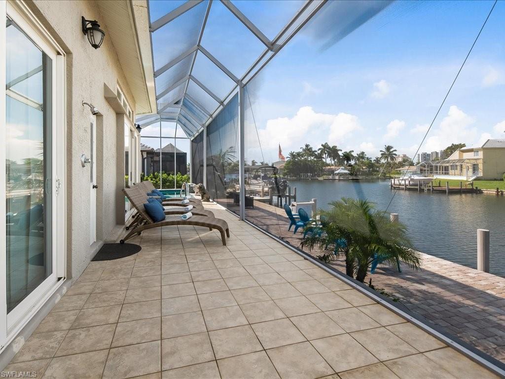 Sunroom / solarium with a water view, a patio, and a pool