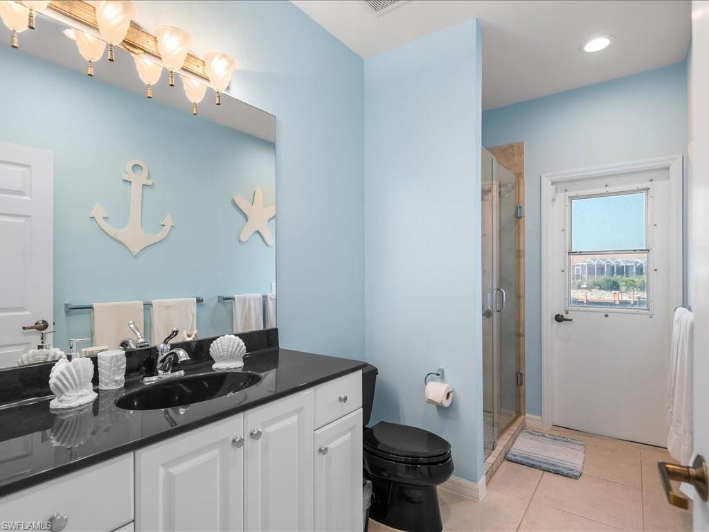 Bathroom with vanity, light tile patterned floors, a shower stall, and recessed lighting