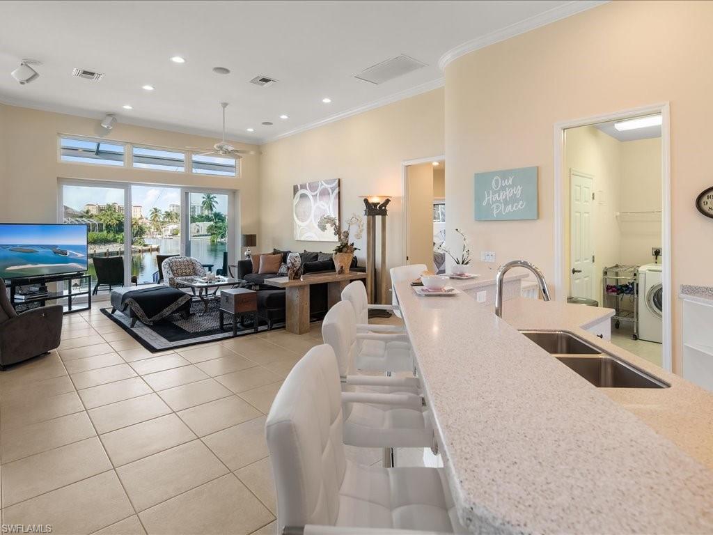Kitchen featuring ornamental molding, light tile patterned flooring, recessed lighting, light stone countertops, and ceiling fan