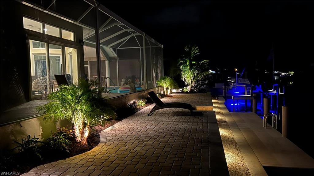 Patio at twilight featuring a sunroom, a patio area, and a lanai