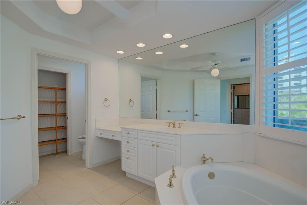 Full Principal bathroom featuring recessed lighting, light tile patterned floors, a bath, vanity, and a ceiling fan
