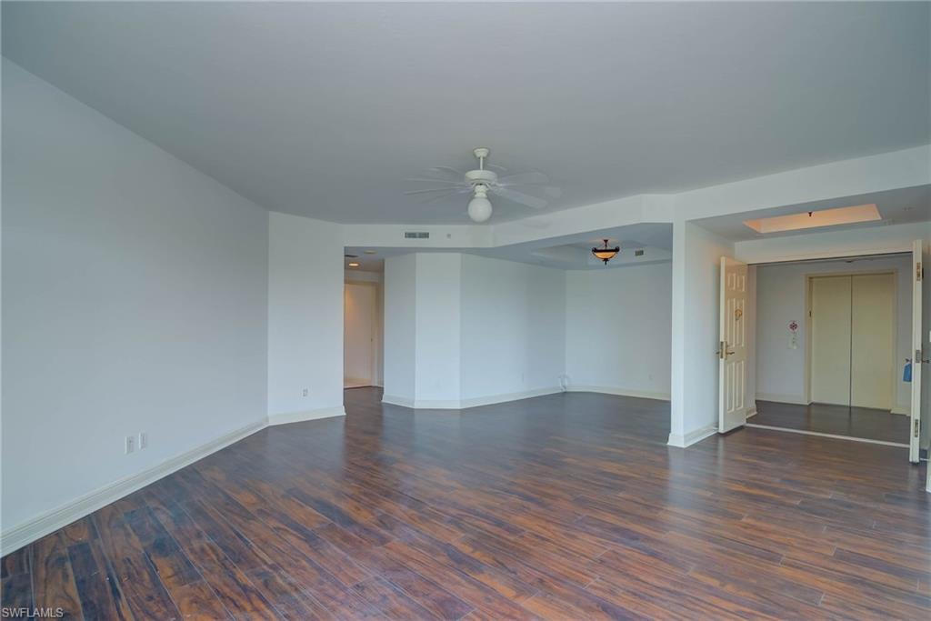 Spare room featuring dark wood-style floors, a ceiling fan, and elevator