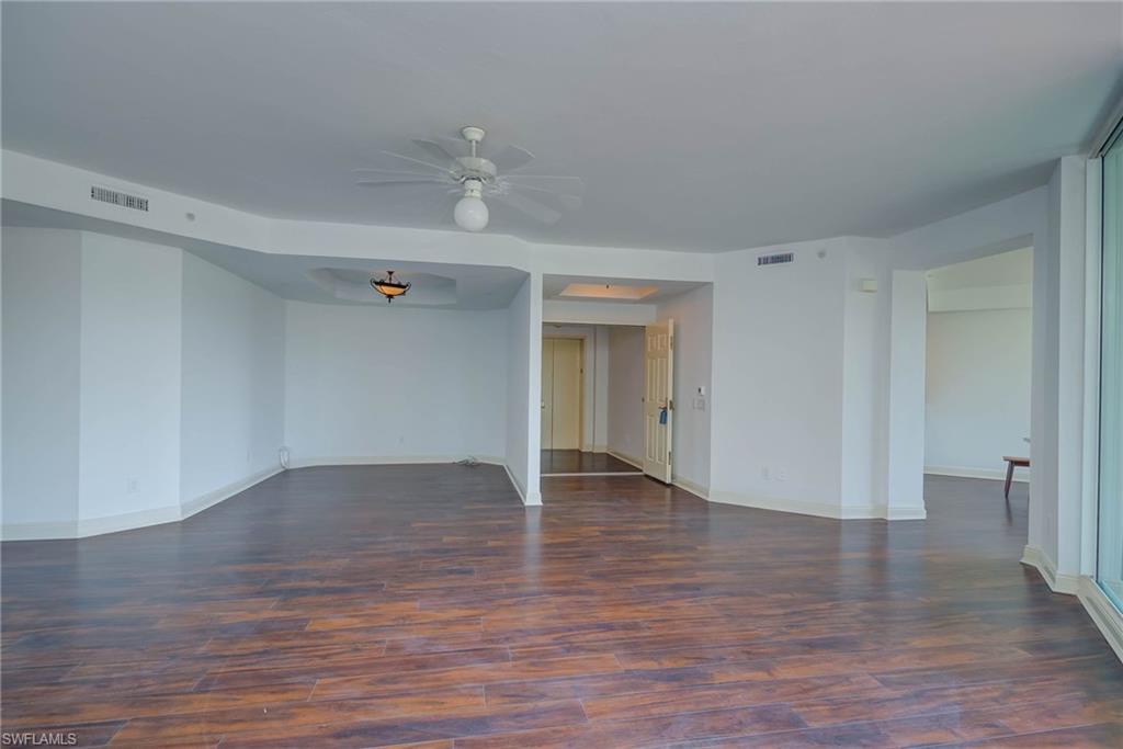 Spare room with dark wood-type flooring and ceiling fan