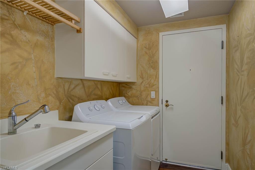 Laundr room featuring washer and dryer and cabinet space. Back door leads to Hall and Service Elevator.