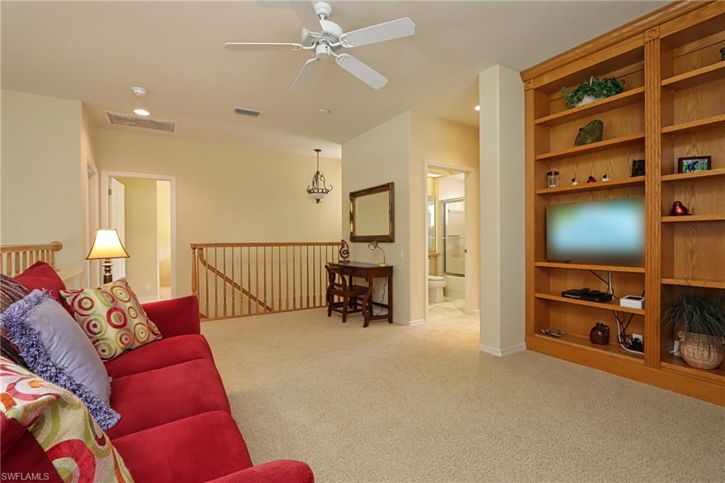 Carpeted living room with ceiling fan
