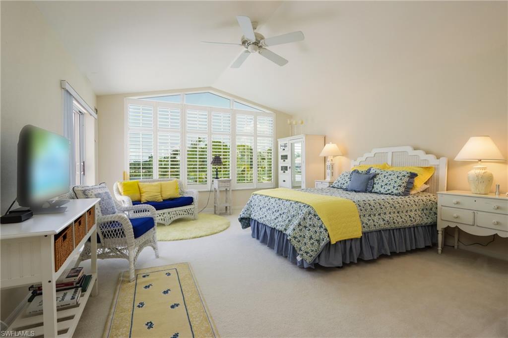 Carpeted bedroom featuring lofted ceiling and ceiling fan