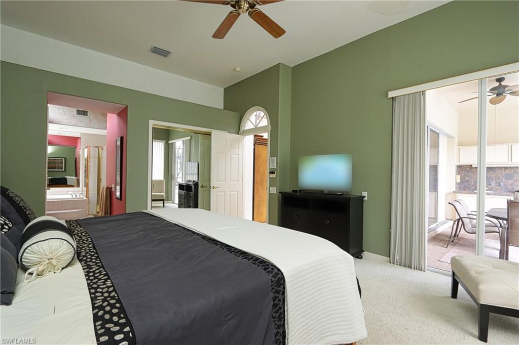 Bedroom featuring multiple windows, ceiling fan, light colored carpet, and access to outside