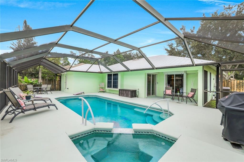 View of pool featuring a sunroom, a patio, a grill, and glass enclosure