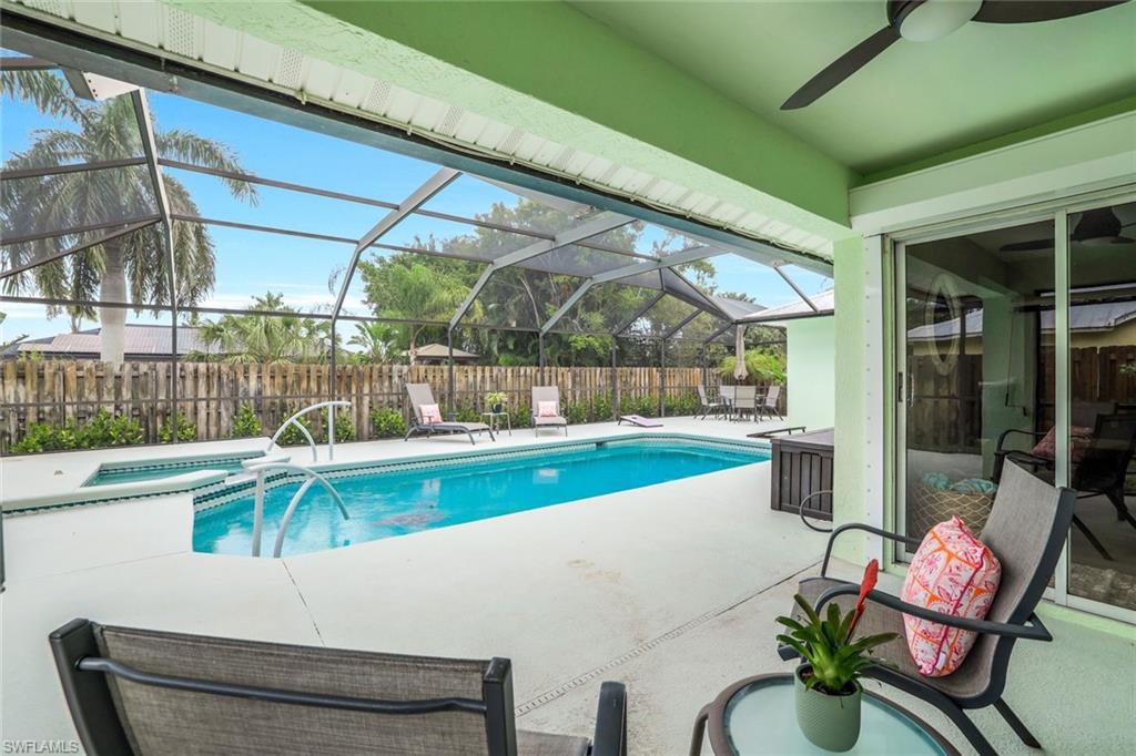 View of swimming pool with a patio area, a lanai, a sunroom, a pool with connected hot tub, and a fenced backyard