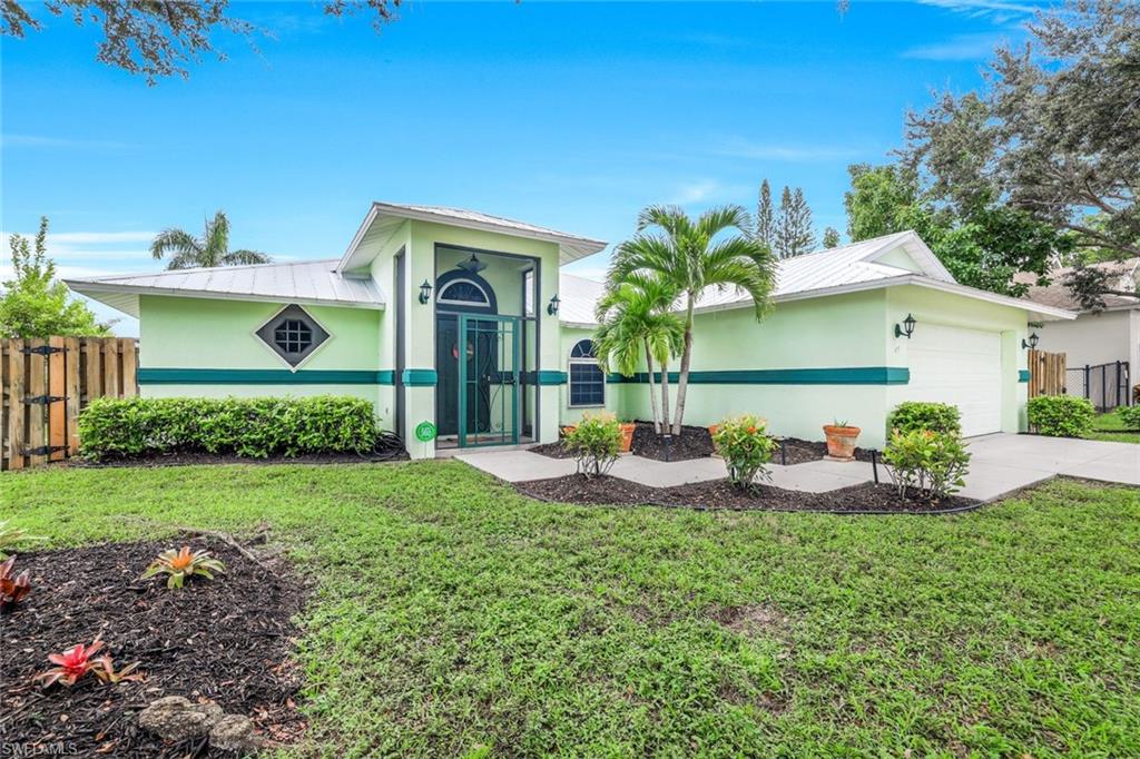 Ranch-style home with a metal roof, stucco siding, a garage, and driveway