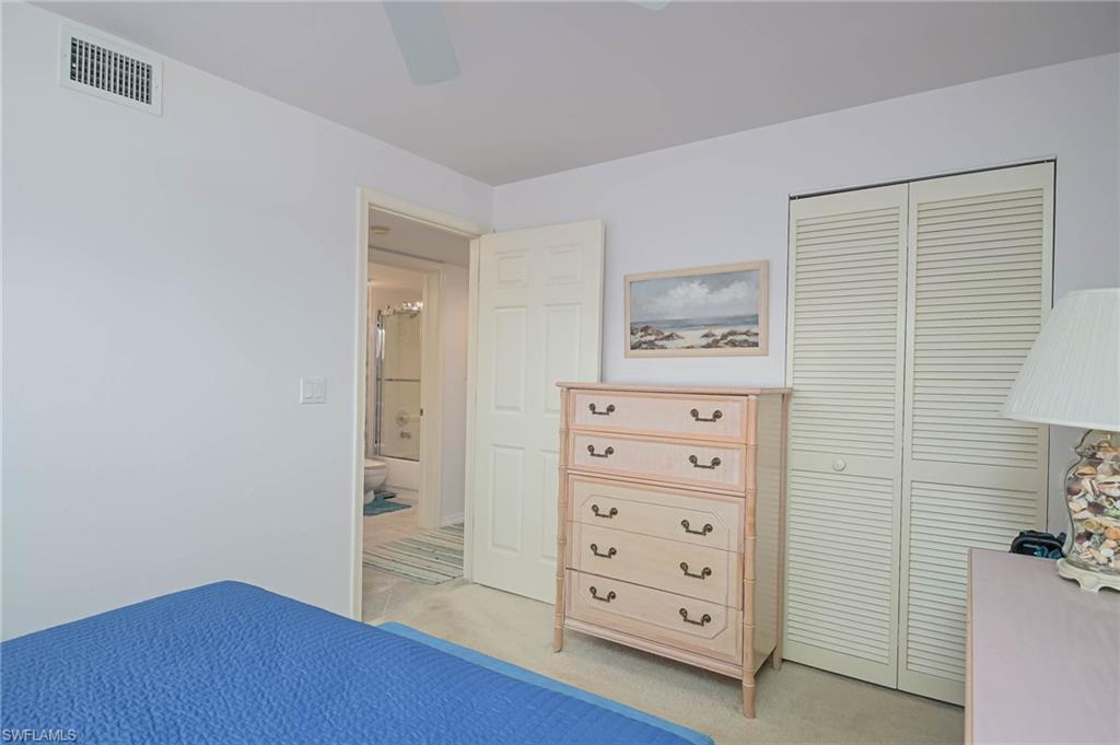 Bedroom with light carpet, a closet, and a ceiling fan