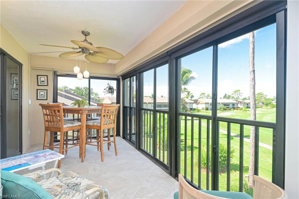 Sunroom / solarium with golf course view and a ceiling fan