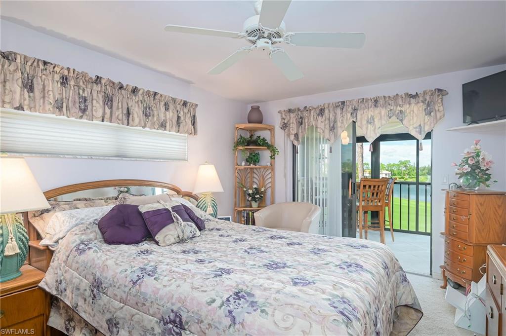 Bedroom featuring light colored carpet, a ceiling fan, and access to exterior