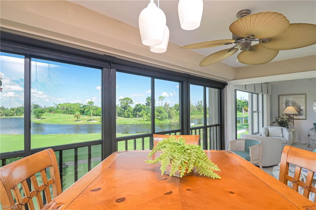 Sunroom with view of wooded area and a water view
