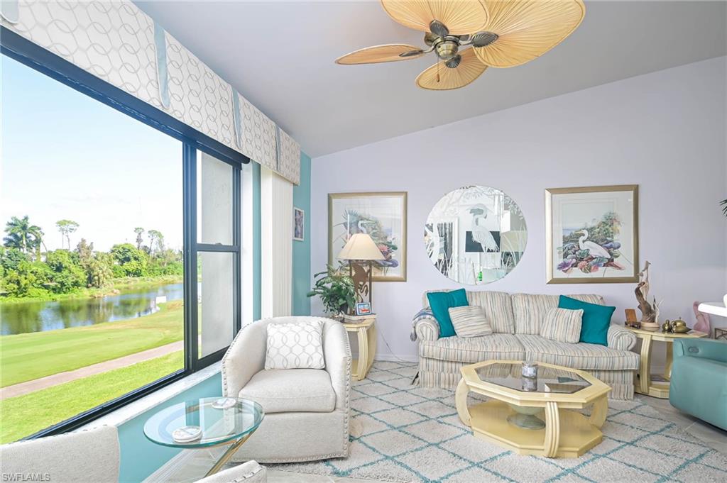 Living room featuring vaulted ceiling, a water view, ceiling fan, and golf course view