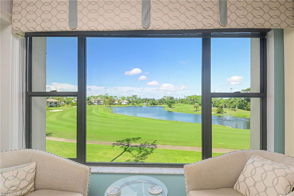 Entryway featuring view of golf course, a water view, and a sunroom