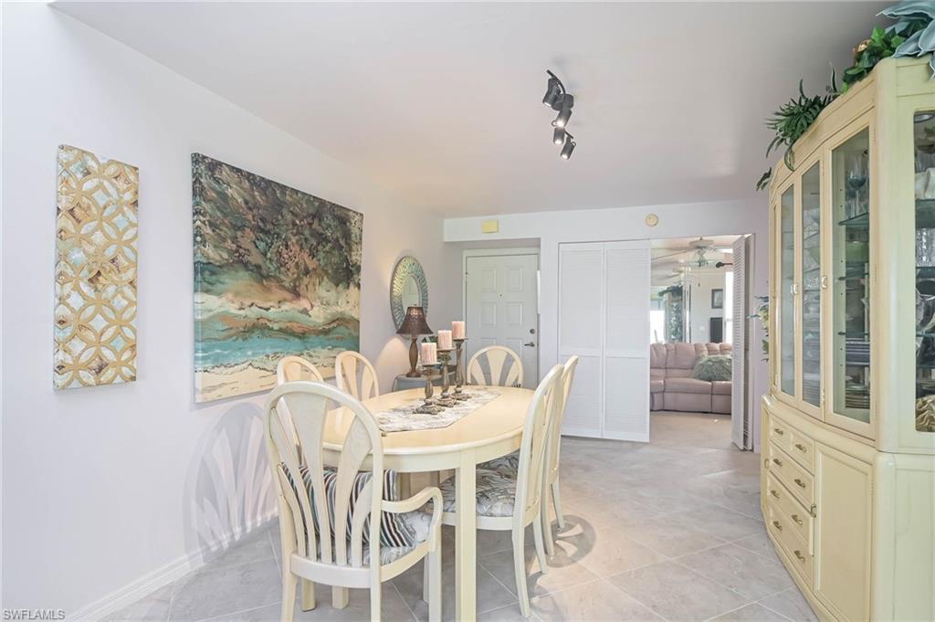 Dining area with light tile patterned floors and track lighting