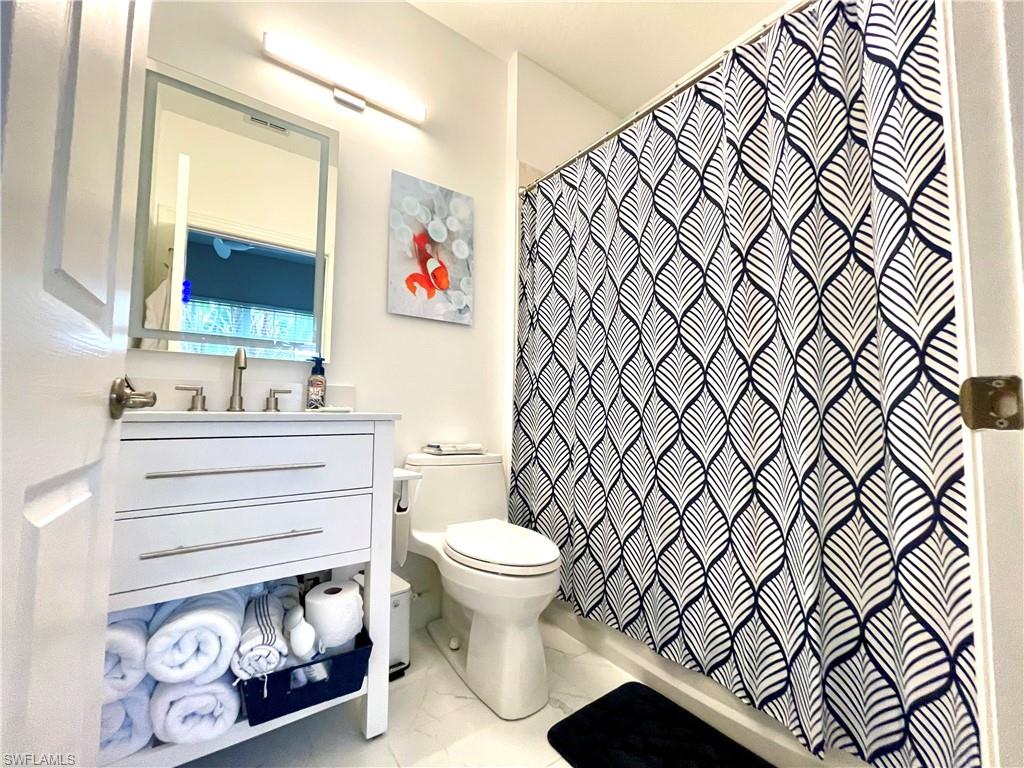 Bathroom featuring vanity and shower / bath combination with curtain
