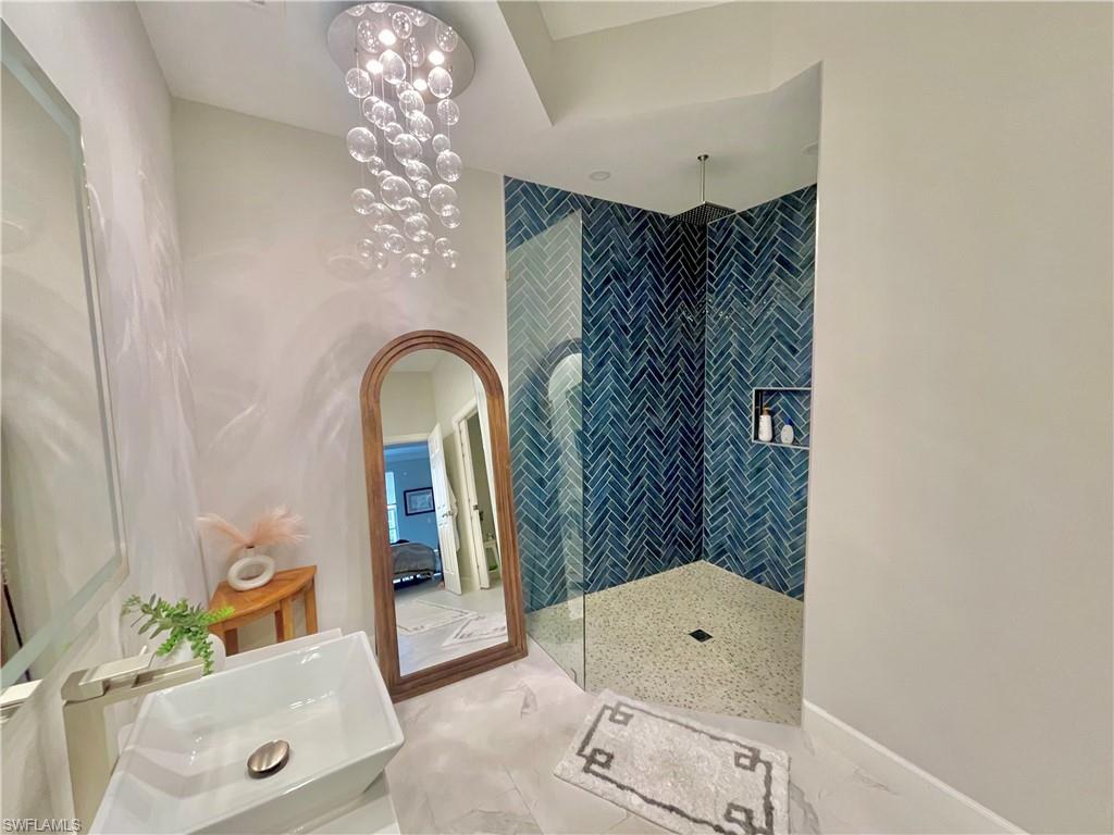 Bathroom with walk in shower, light tile patterned floors, and ensuite bath