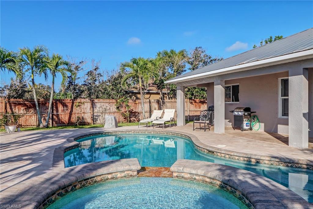 View of pool with a fenced backyard, a pool with connected hot tub, and a patio