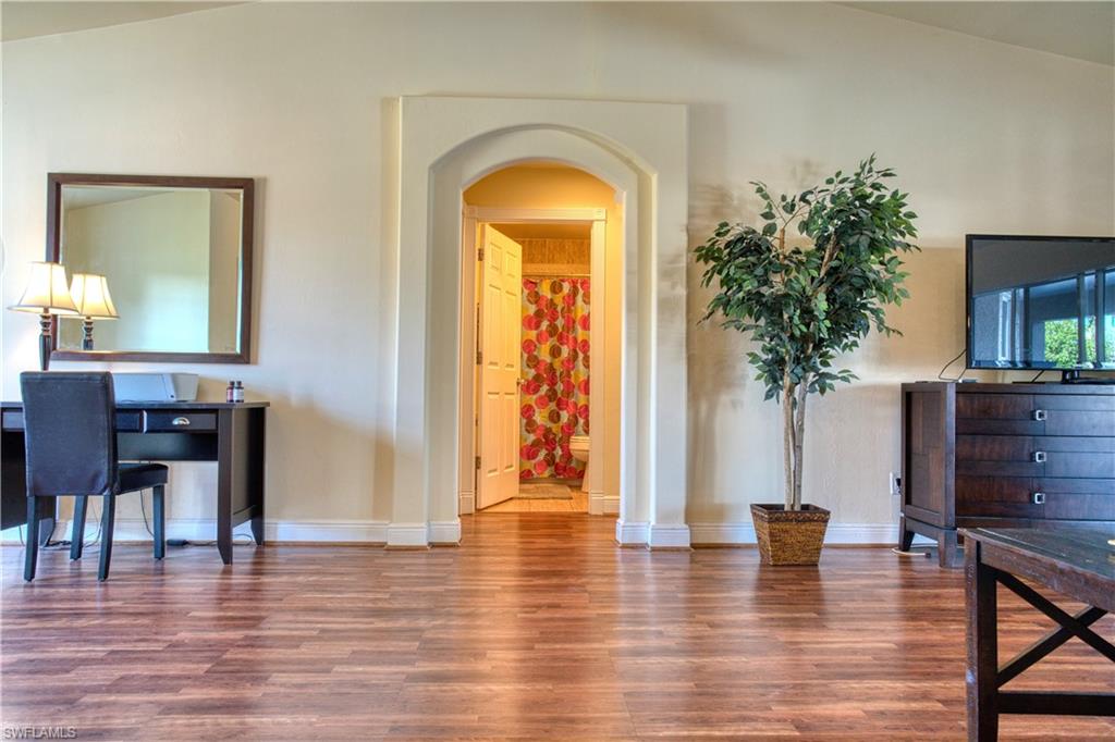 Living area with wood finished floors and arched walkways