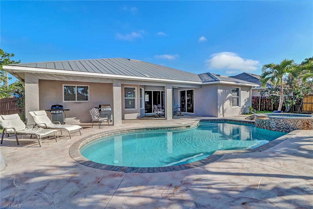 Fenced backyard with a patio area, ceiling fan, area for grilling, and outdoor dining area