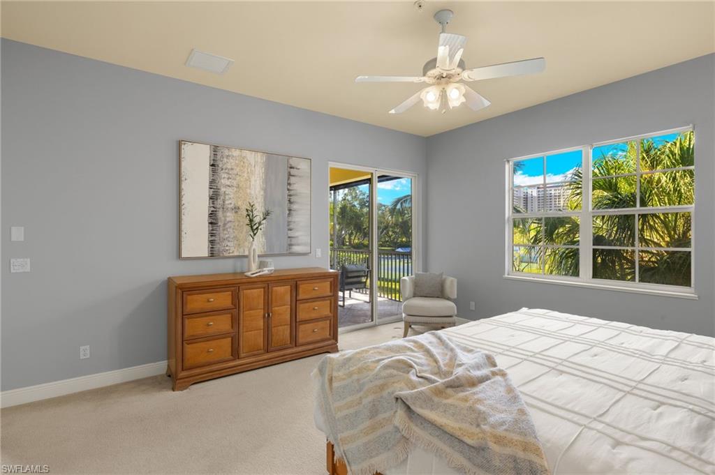 Bedroom with light colored carpet, multiple windows, baseboards, and access to exterior