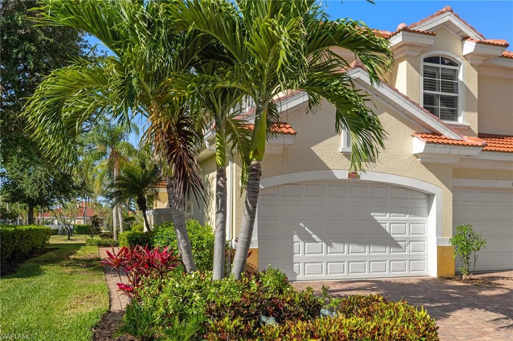 View of home's exterior with stucco siding, a tiled roof, 2 car garage and driveway