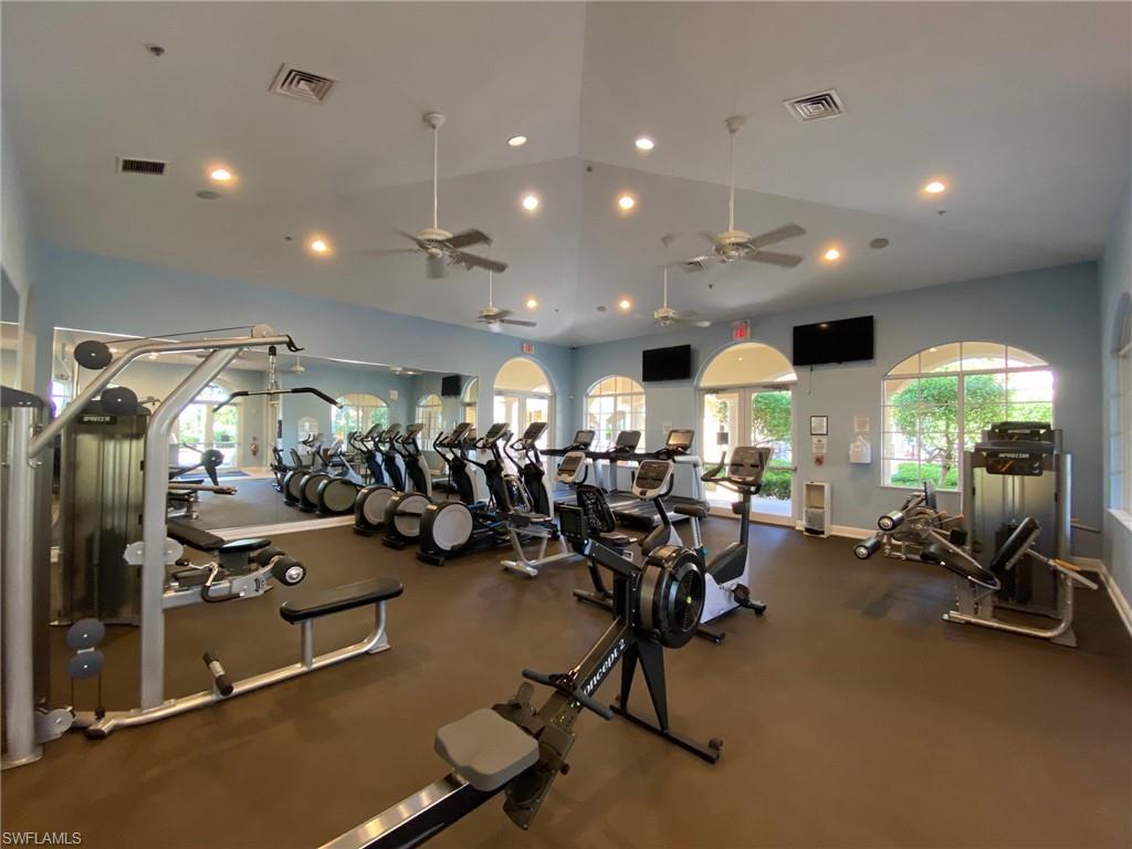 Exercise room with a ceiling fan, recessed lighting, baseboards, and vaulted ceiling