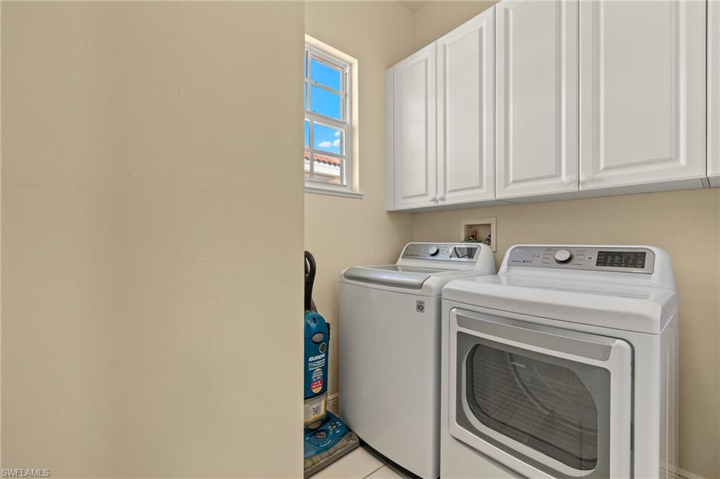 Washroom featuring washing machine and clothes dryer and cabinet space