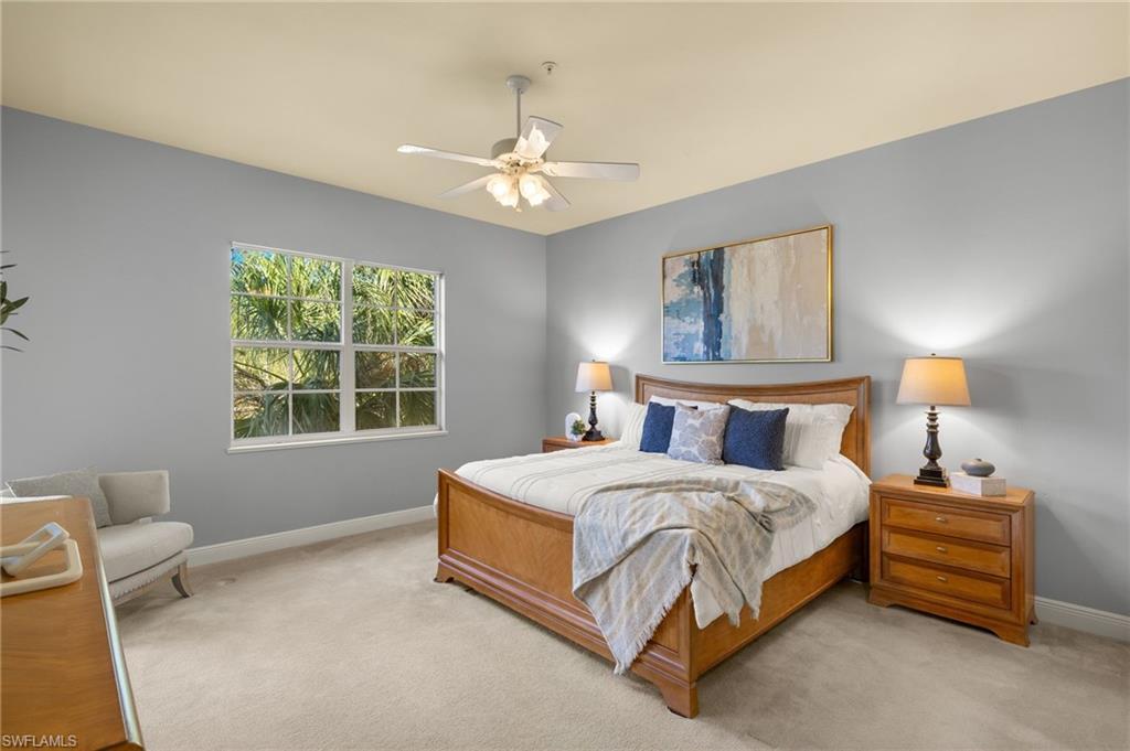 Bedroom featuring light colored carpet, baseboards, and ceiling fan