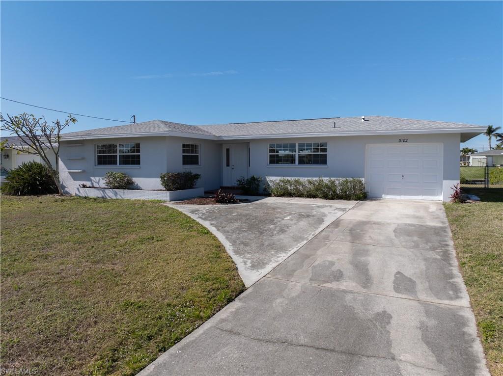 Single story home with a garage and a front yard