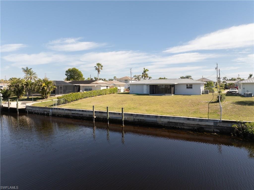 View of dock with a yard and a water view