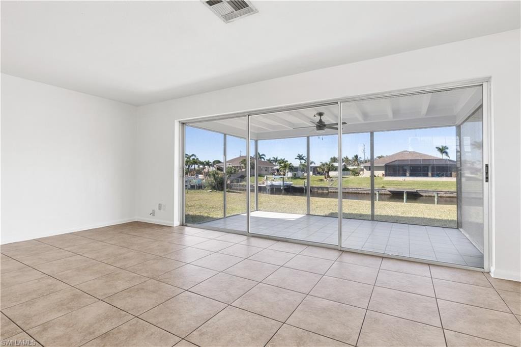 Unfurnished room with light tile patterned flooring, plenty of natural light, and ceiling fan