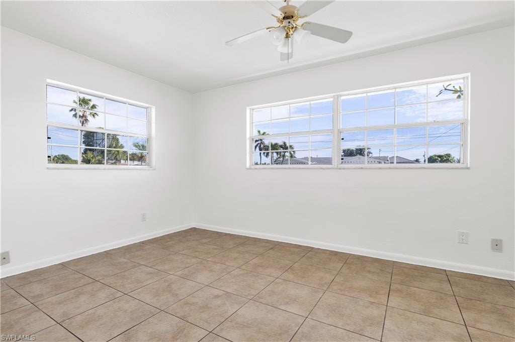 Empty room featuring light tile patterned floors and ceiling fan