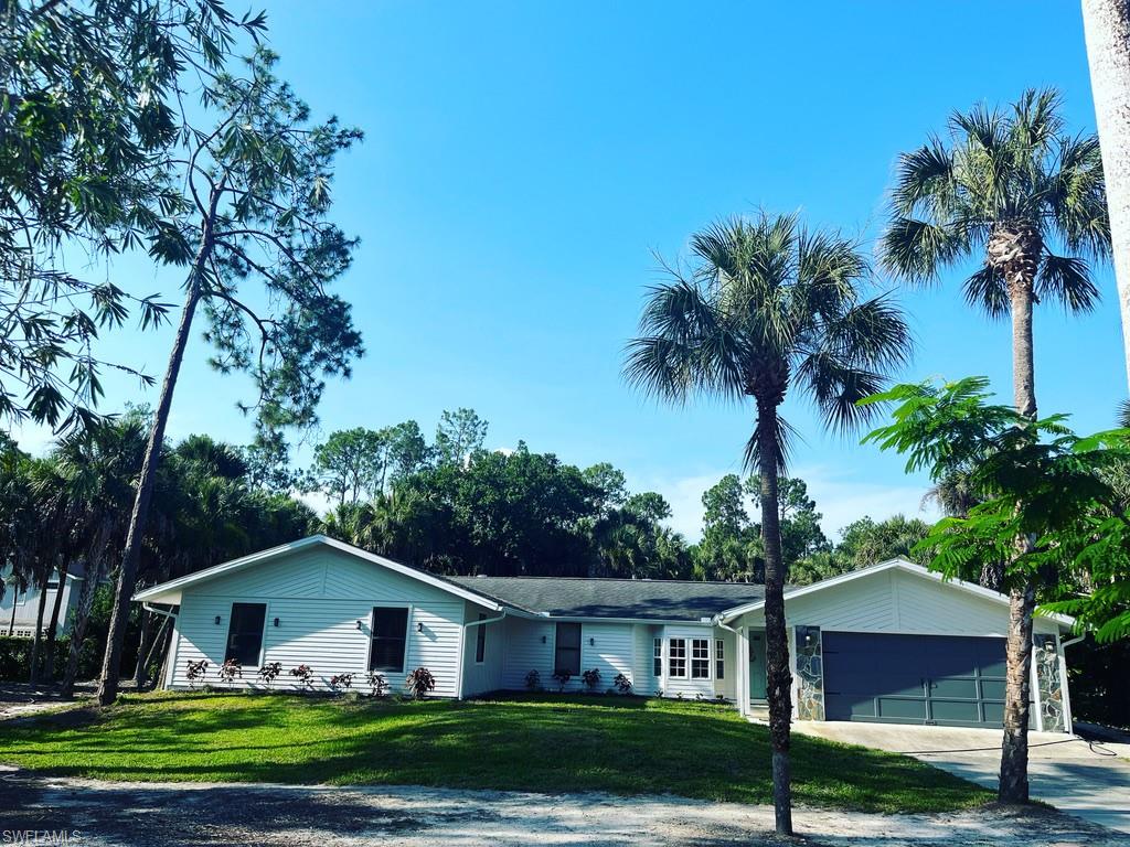 Ranch-style home featuring a front lawn, concrete driveway, and a garage