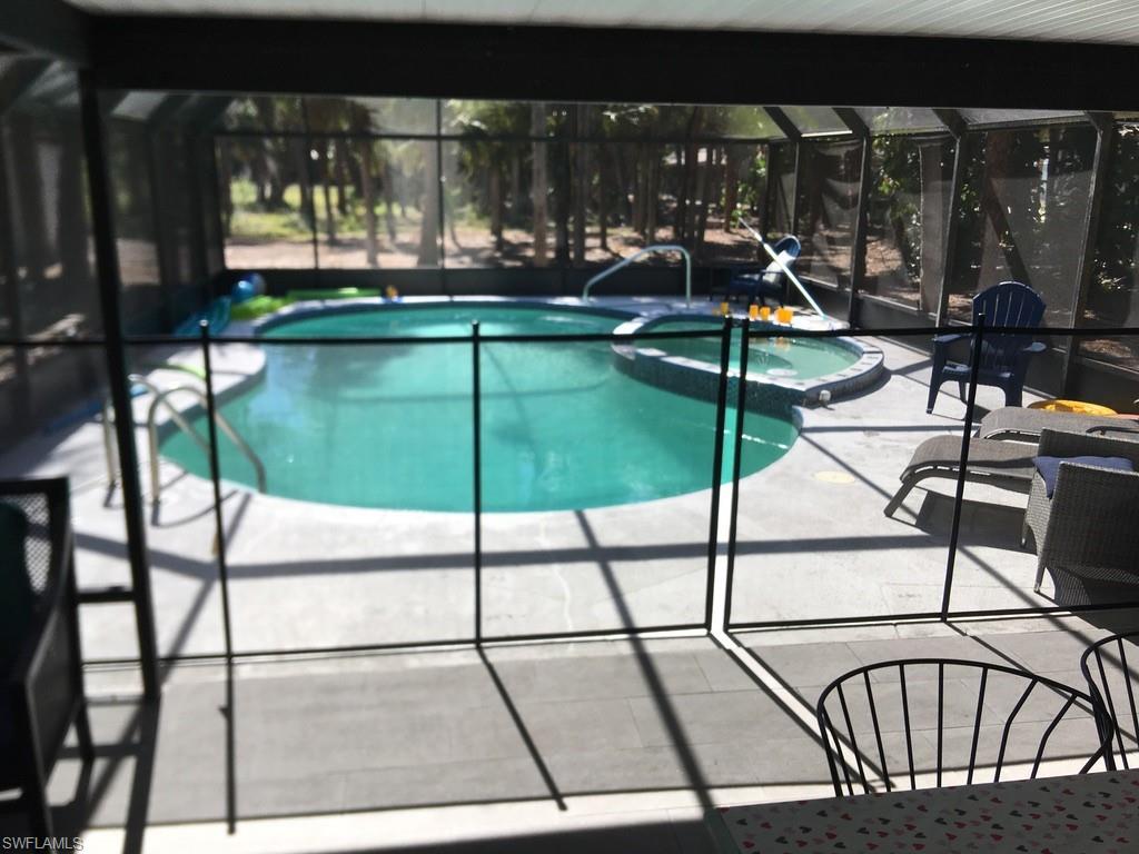 View of swimming pool with a sunroom, a pool with connected hot tub, a lanai, and a patio area