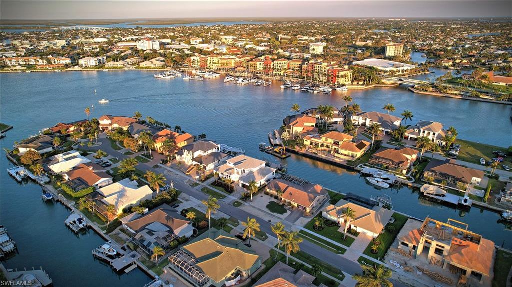 Aerial view of property and surrounding area featuring a nearby body of water and nearby suburban area