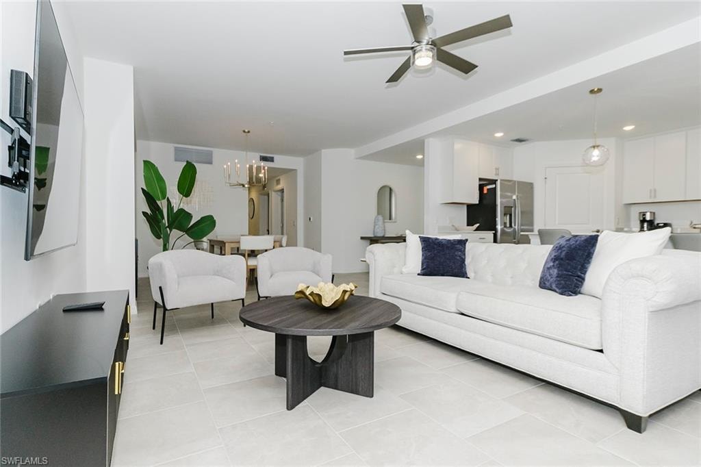 Living room featuring ceiling fan, hanging lights, and light tile patterned flooring