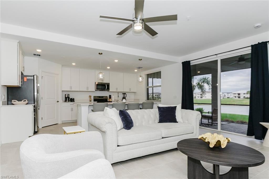 Living room with ceiling fan, recessed lighting, and light tile patterned floors