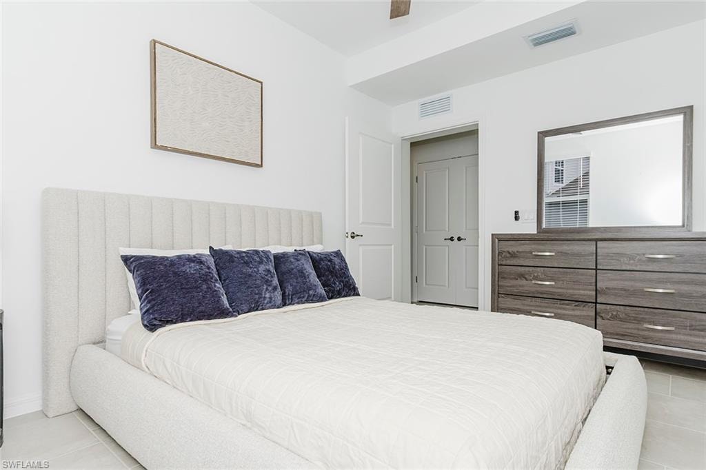 Bedroom featuring light tile patterned floors and ceiling fan