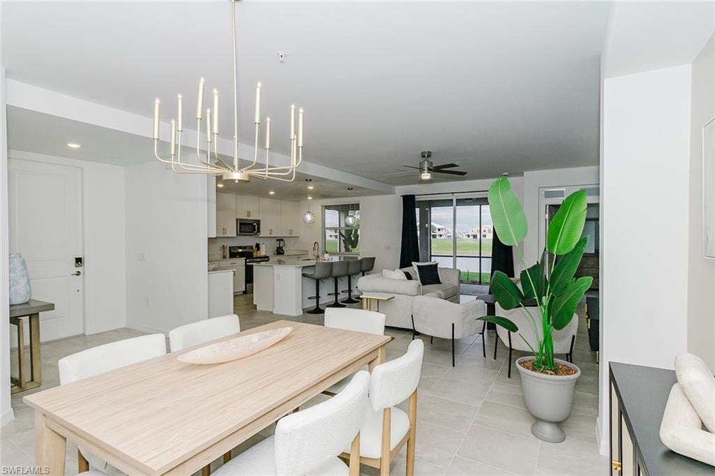 Dining space featuring a ceiling fan, a chandelier, and light tile patterned floors