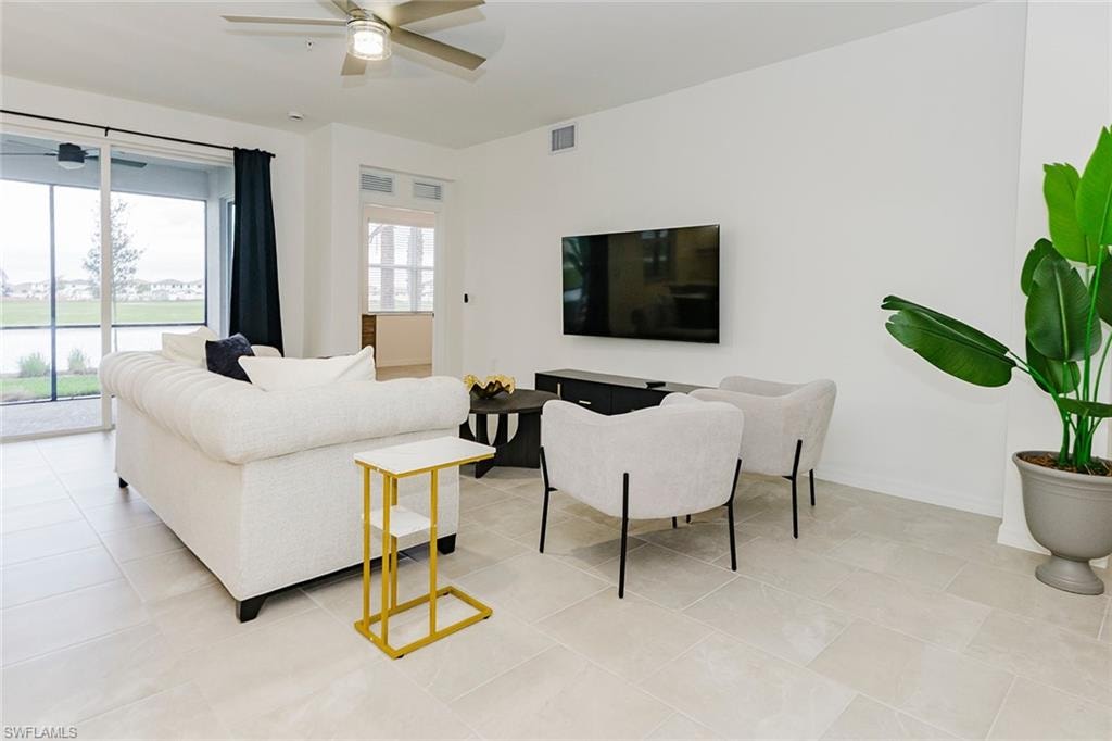 Living room with a ceiling fan and light tile patterned floors