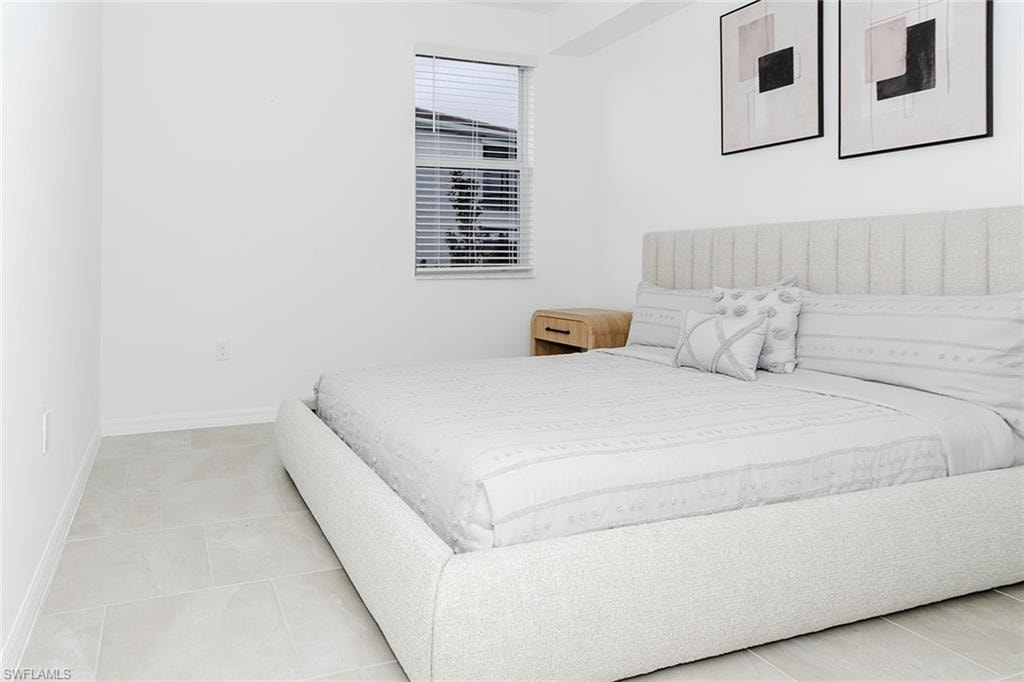 Bedroom with baseboards and light tile patterned flooring