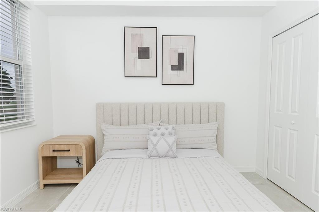 Bedroom featuring light tile patterned floors and a closet