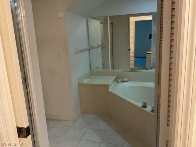 Bathroom featuring light tile patterned floors and a garden tub