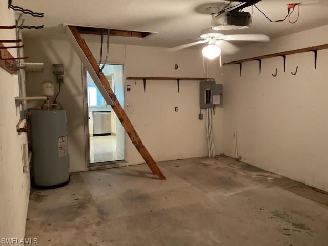 Basement featuring water heater, electric panel, ceiling fan, and a garage