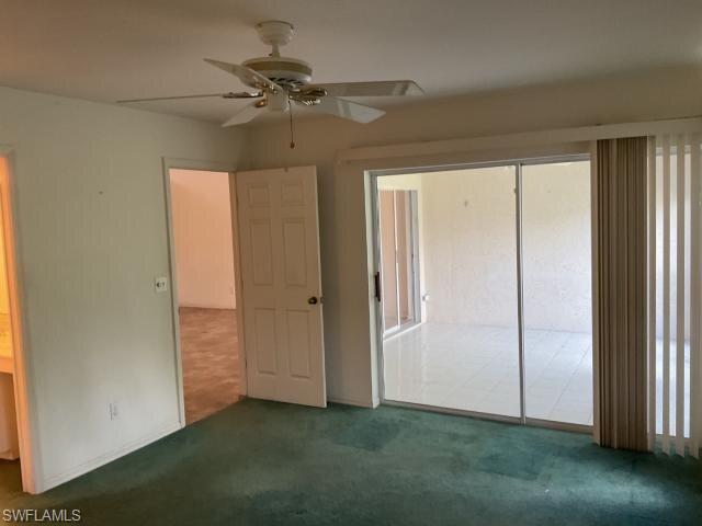 Unfurnished bedroom featuring dark carpet and a ceiling fan